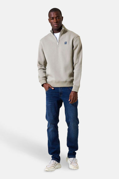 Kaki sweat met opstaande kraag van GARCIA, gedragen met een wit T-shirt, een blauwe jeans en witte sneakers.