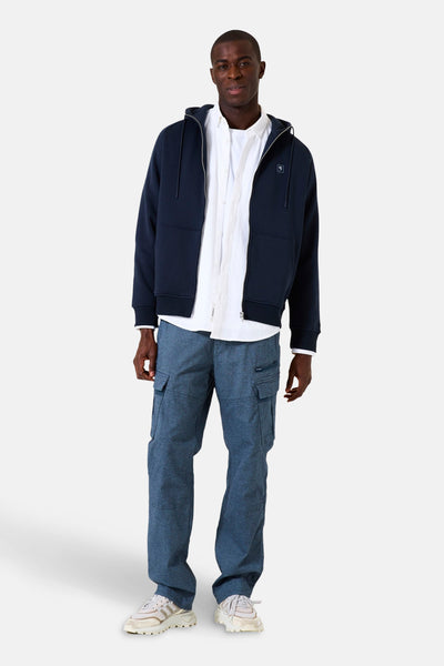 Blauwe GARCIA bodywarmer gedragen over een wit overhemd en een blauwe cargobroek.
