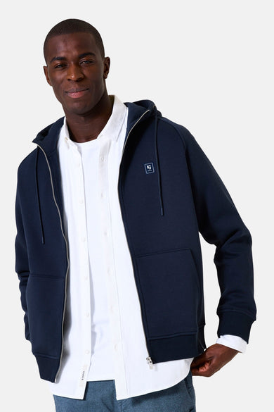 Marineblauwe ritsgilet van GARCIA gedragen over een wit overhemd en een canvas broek.