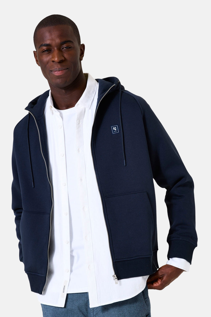 Marineblauwe ritsgilet van GARCIA gedragen over een wit overhemd en een canvas broek.