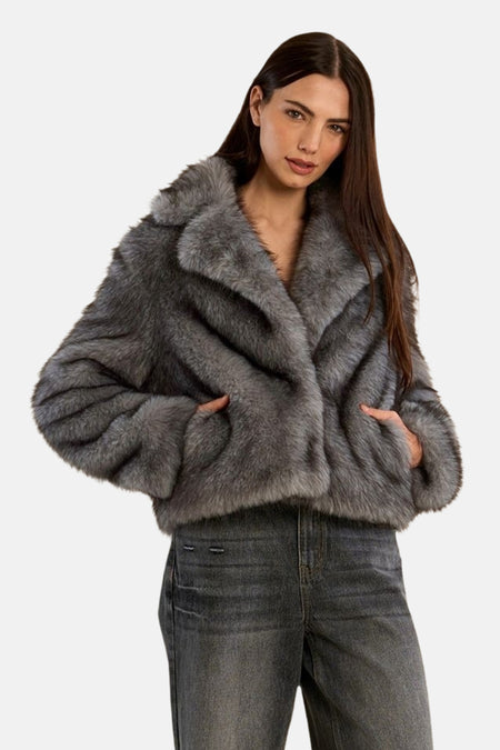 Veste courte grise à col oversize et poches, portée par un mannequin