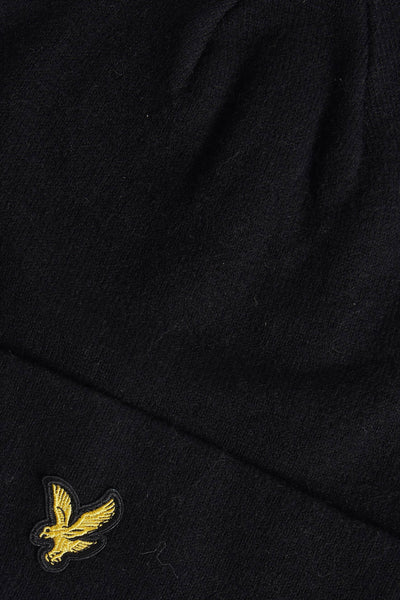 Zwarte gebreide muts van LYLE & SCOTT met een geborduurd gouden adelaarslogo.