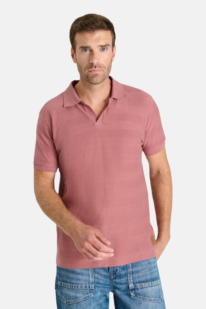 Korte mouwen polo baksteen van Le Temps des Cerises, van achteren gezien, gedragen met een blauwe jeans.
