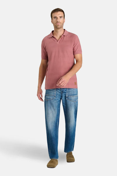 Bakstenen poloshirt met korte mouwen van Le Temps des Cerises, gedragen met een blauwe jeans en bruine schoenen.
