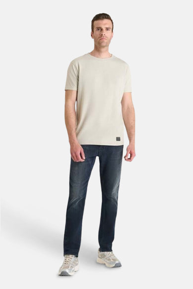 Beige T-shirt met korte mouwen van Le Temps des Cerises, gedragen met een donkerblauwe jeans en sneakers.