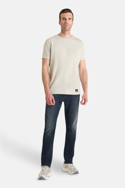 Beige T-shirt met korte mouwen van Le Temps des Cerises, gedragen met een donkerblauwe jeans en sneakers.