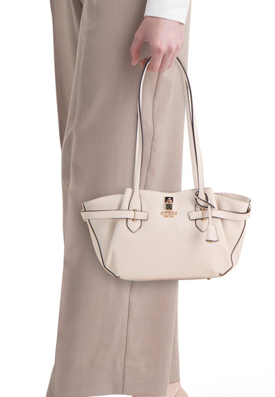 Ecru leather shoulder bag by Celine with black piping, gold-tone hardware, and front buckle details, shown in side view on model wearing beige trousers.