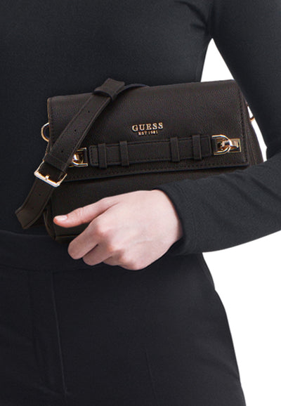 Sac à bandoulière noir de Guess, porté à l'épaule avec une bandoulière réglable et des détails dorés.