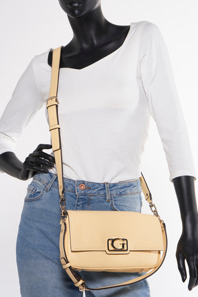 Geel Guess schouderzak, gedragen op een mannequin in jeans en een witte t-shirt.