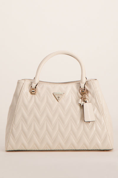 Sac à main écru de Guess, avec motif chevron en relief et breloque décorative.
