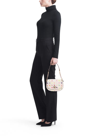 Sac à bandoulière multicolore de Guess, orné de motifs floraux et porté avec un pull noir et un pantalon assorti.