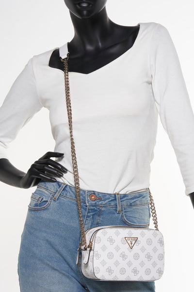 Witte Guess schoudertas met logoprint, gedragen met een spijkerbroek en een witte top.