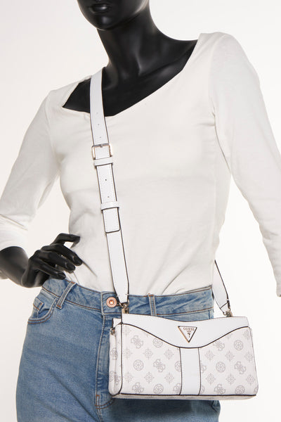 Witte Guess schoudertas met monogramprint gedragen met een blauwe jeans en een witte top.