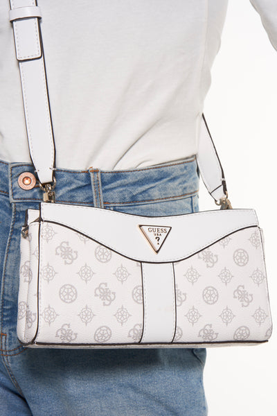 Witte Guess schoudertas met monogrampatroon, gedragen over een wit T-shirt en een lichtblauwe jeans.
