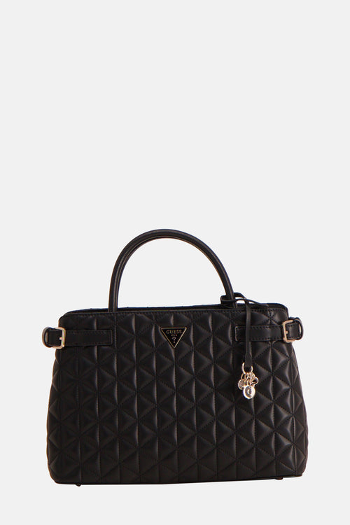Zwarte Guess handtas, gewatteerd met bedeltjes en gouden afwerkingen.