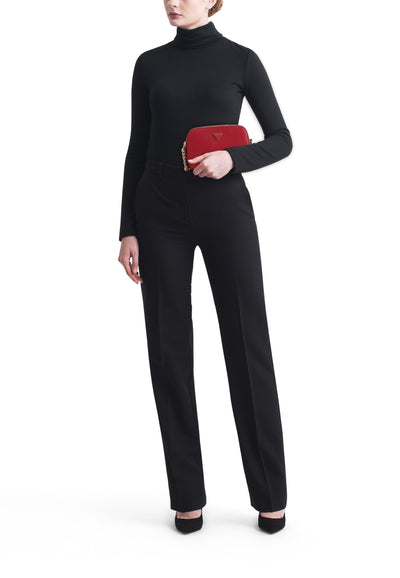 Sac à bandoulière rouge de Guess, porté avec un pantalon noir taille haute et un pull noir à col roulé.