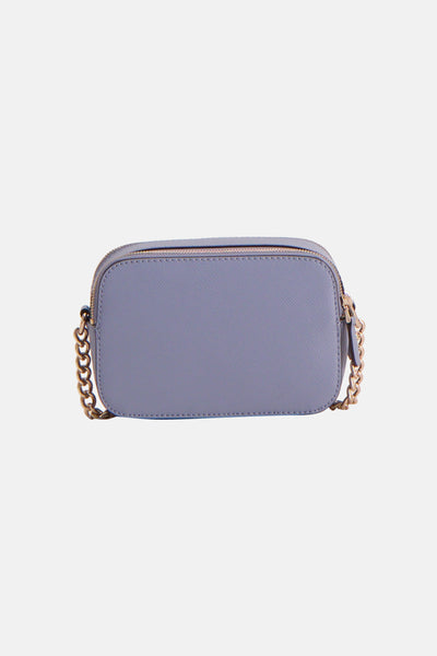Sac à bandoulière bleu Guess avec bandoulière chaîne dorée, fermeture éclair dorée et texture grainée.