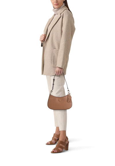 Bruine Guess schoudertas, gedragen over de schouder, met een beige jas en bruine hakken.
