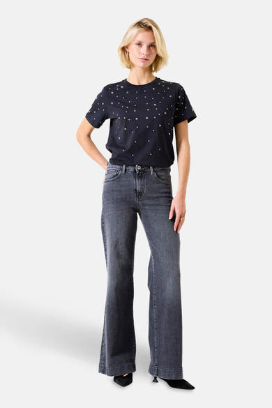 T-shirt noir à manches courtes de GARCIA, orné d'étoiles et porté avec un jean gris.