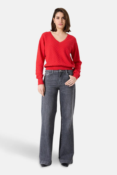 Pull à col en V rouge de GARCIA, avec un motif texturé et une coupe décontractée, porté avec un jean gris.
