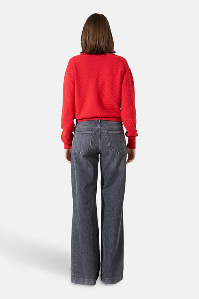 Pull à col en V rouge de GARCIA avec motif texturé, porté avec un pantalon en denim foncé.