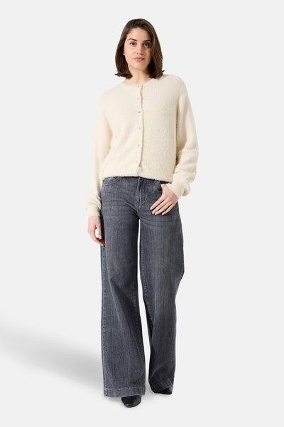 Cardigan écru de GARCIA porté avec un jean ample gris et des chaussures noires.