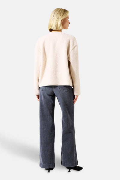 Ecru jas met bouclé breisel van GARCIA, van achteren gezien, gedragen met een donkerblauwe flared jeans en zwarte pumps.