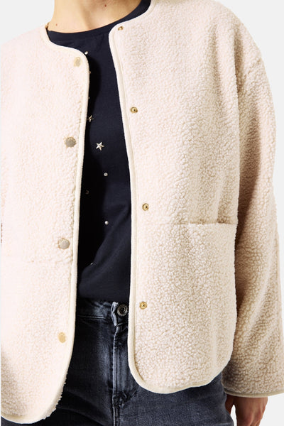 Veste écru en teddy par GARCIA, avec boutons dorés et poche plaquée, portée avec un T-shirt étoilé et un jean.
