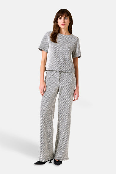 Gekleurde broek van GARCIA, met diagonale strepen over het hele oppervlak, wijde pasvorm, gedragen met een bijpassend topje en zwarte schoenen.