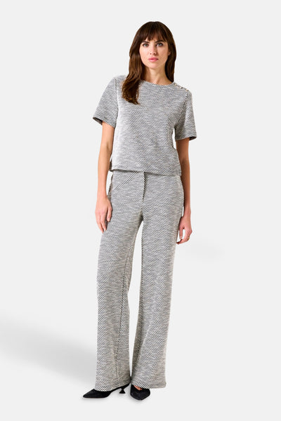 Gekleurde broek van GARCIA, met diagonale strepen over het hele oppervlak, wijde pasvorm, gedragen met een bijpassend topje en zwarte schoenen.