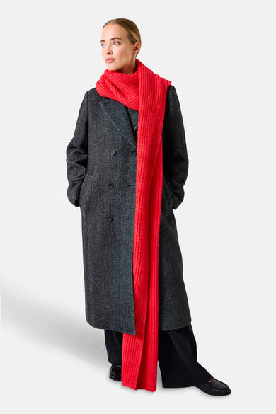Écharpe rouge de GARCIA, longue et tricotée, portée avec un manteau long à chevrons.
