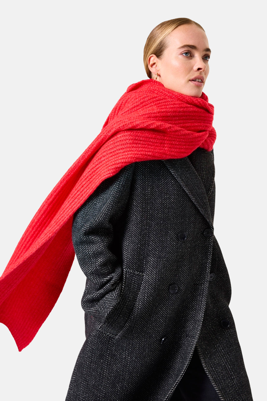 Écharpe rouge de GARCIA, tricotée avec une texture épaisse, portée avec un manteau à chevrons gris foncé.
