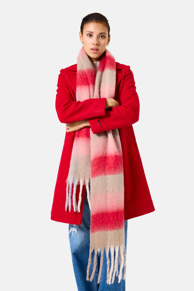 Écharpe rayée rouge et beige de GARCIA, avec des franges décoratives, portée avec un manteau rouge et un jean bleu.
