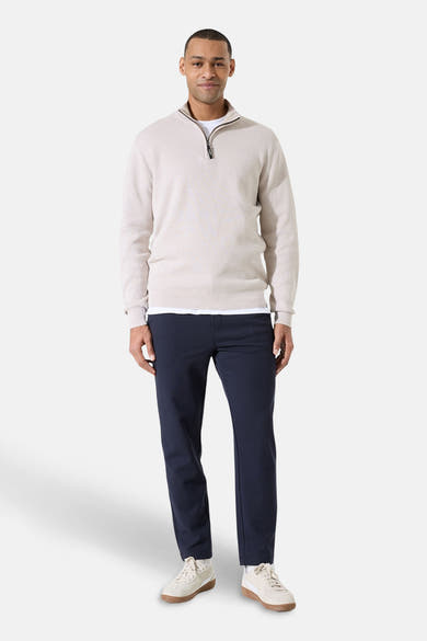 Beige coltrui van GARCIA, gedragen met een marineblauwe broek en crèmekleurige sneakers.