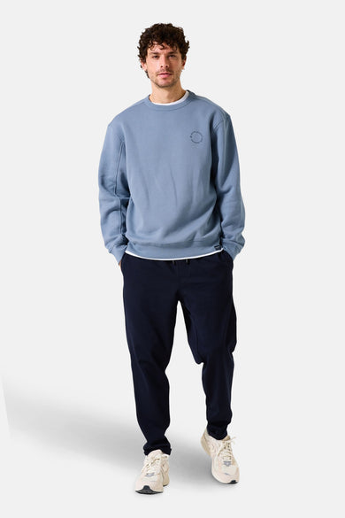 Lichtblauwe trui van GARCIA, met een ronde hals en gedragen met een marineblauwe joggingbroek.
