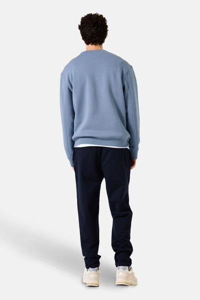 Blauwe trui van GARCIA, met een ronde hals, gedragen met een marineblauwe joggingbroek en lichte sneakers.