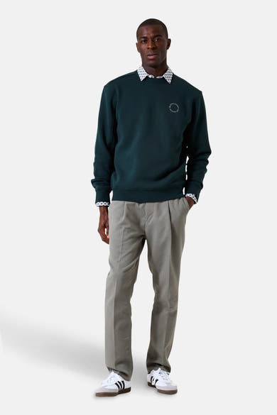 Groene sweater van GARCIA met een discreet patroon, gedragen over een overhemd met patroon en een grijze broek.