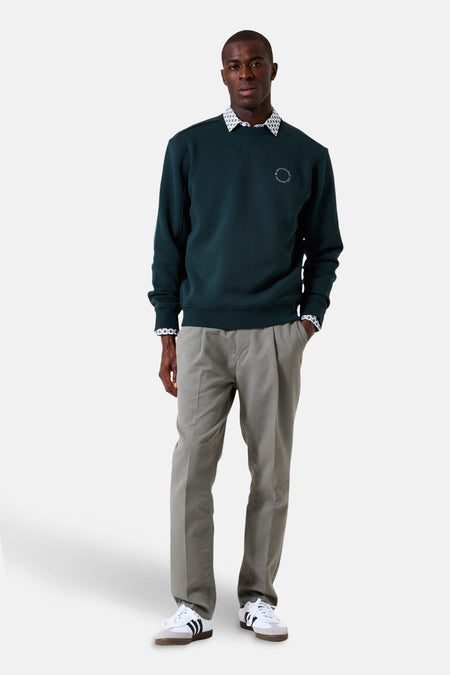 Groene sweater van GARCIA met een discreet patroon, gedragen over een overhemd met patroon en een grijze broek.