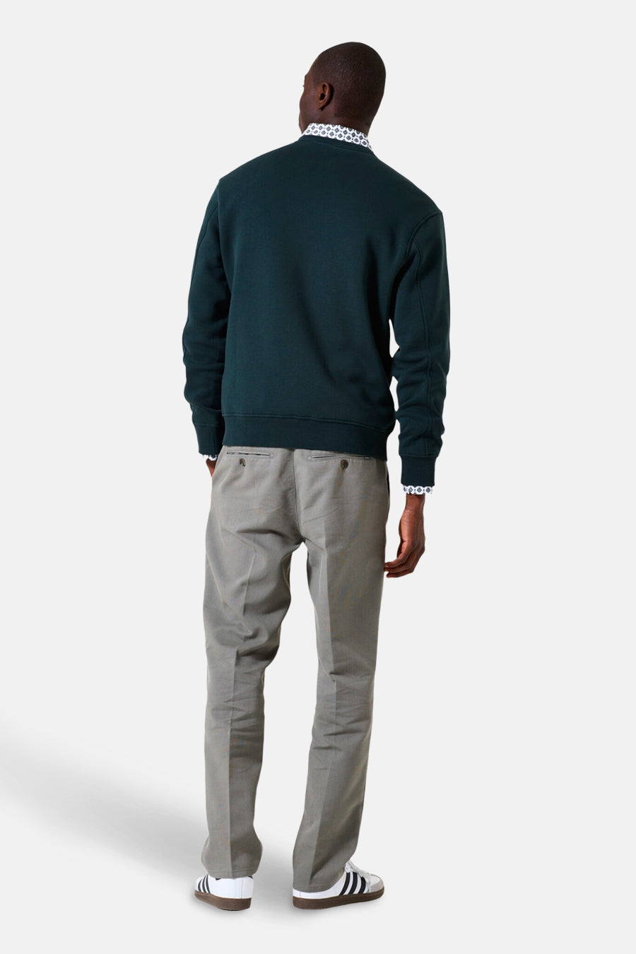 Groene GARCIA trui, gedragen met een bedrukt overhemd en een grijze broek, van achteren gezien.
