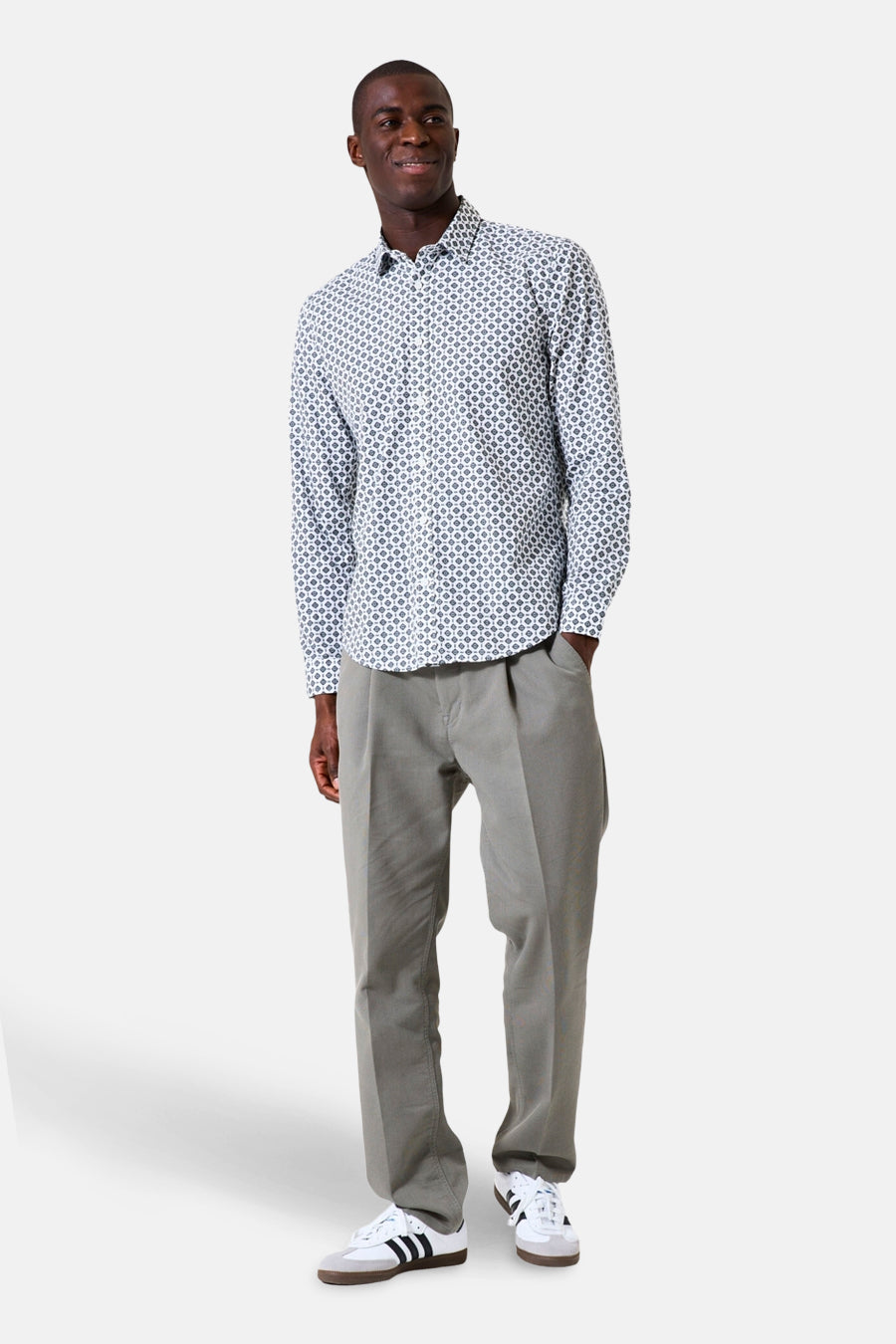 Chemise à manches longues blanche à motifs géométriques de GARCIA, portée avec un pantalon gris et des baskets blanches.