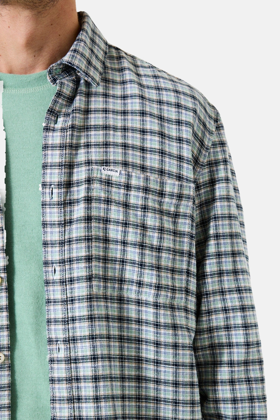 Chemise à manches longues multicolore de Garcia, à motif carreaux, portée sur un t-shirt vert.
