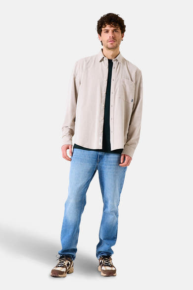 Beige overhemd met lange mouwen van GARCIA, gedragen open over een donker T-shirt en een lichtblauwe jeans.