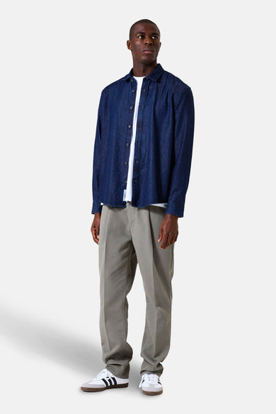 Lange mouwen overhemd in donkerblauw denim van GARCIA, gedragen open over een wit T-shirt en een kaki broek.