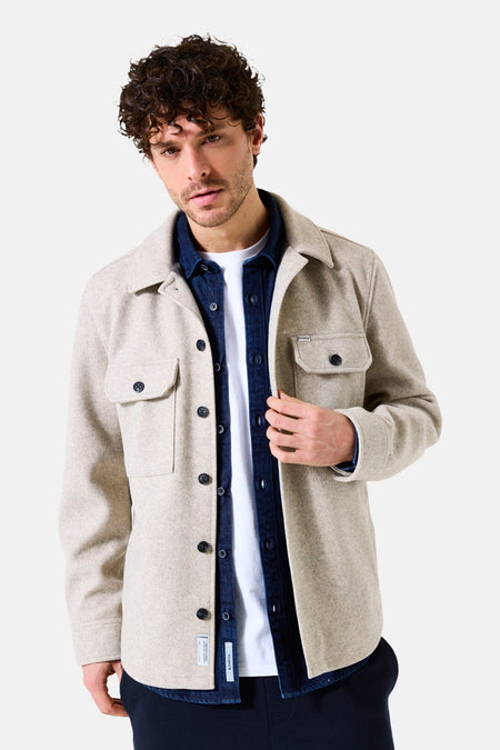 Beige overhemd met lange mouwen van GARCIA, gedragen over een wit T-shirt en een blauw spijkeroverhemd.