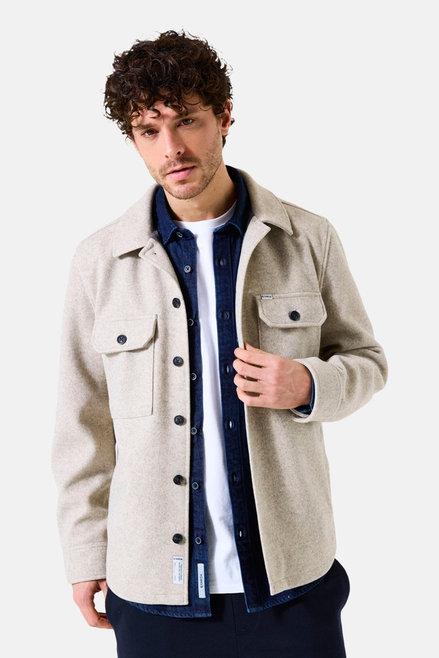 Beige overhemd met lange mouwen van GARCIA, gedragen over een wit T-shirt en een blauw spijkeroverhemd.