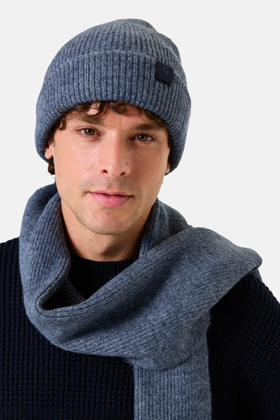 Bonnet bleu de GARCIA en tricot côtelé, porté avec une écharpe assortie et un pull foncé.