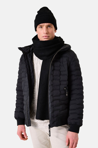 Écharpe noire par GARCIA, portée avec un bonnet noir et une veste matelassée.