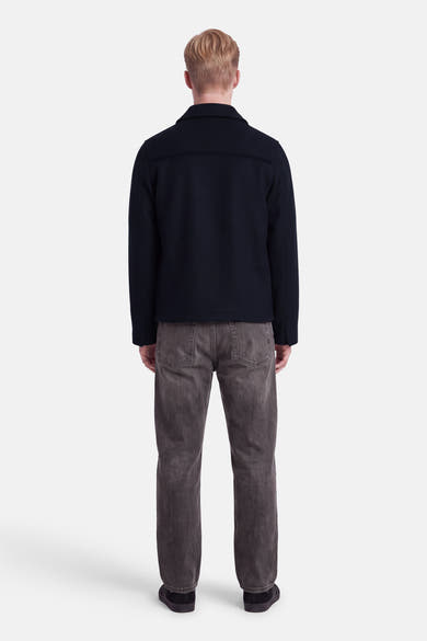 Veste courte bleu marine INDIGOLD vue de dos, portée avec un jean gris.