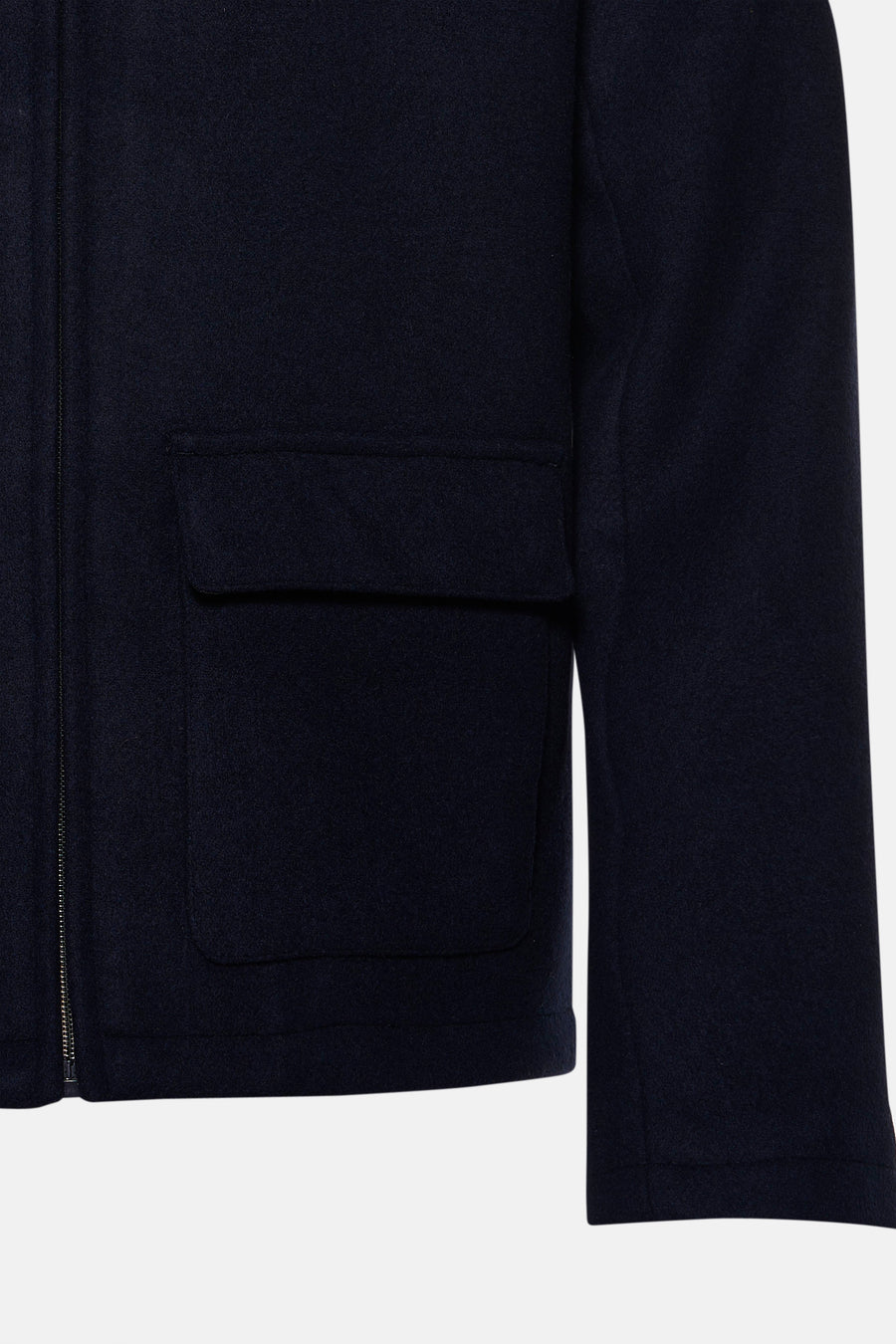 Détail d’une veste courte bleu marine INDIGOLD avec fermeture zippée et poches à rabat.