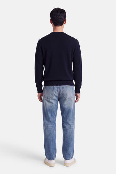 Pull col rond bleu marine par INDIGOLD, vue dos, en maille fine, porté avec jeans délavés et baskets blanches